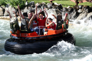 Eine Gruppe von Personen die in einer Wildwasserbahn sitzen